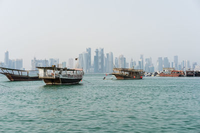 Boats in sea against skyline