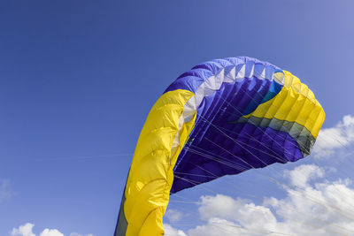 Low angle view of parachute against blue sky