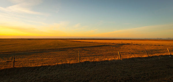 Scenic view of field against sky during sunset