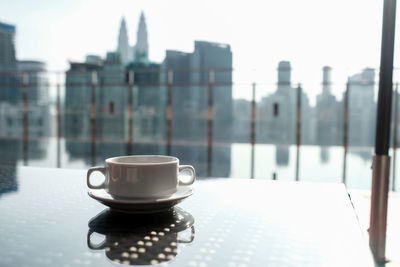 Coffee cup on window in city