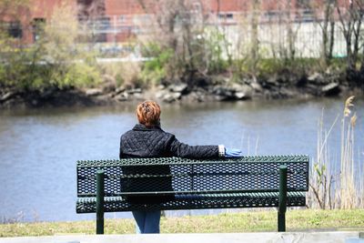 Man sitting on bench in lake