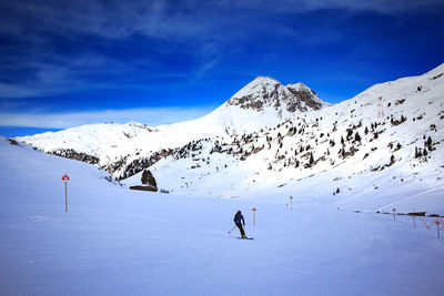 Men skiing on snowcapped mountain against sky