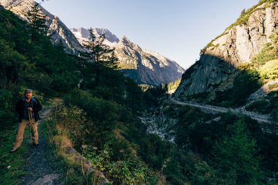 Man standing by tree against mountains