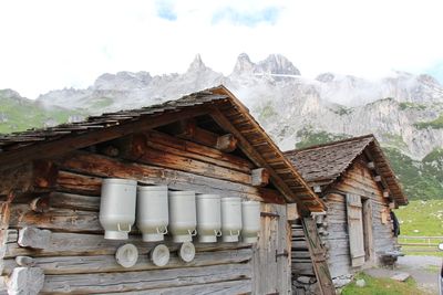 Milk canisters on wooden cottage