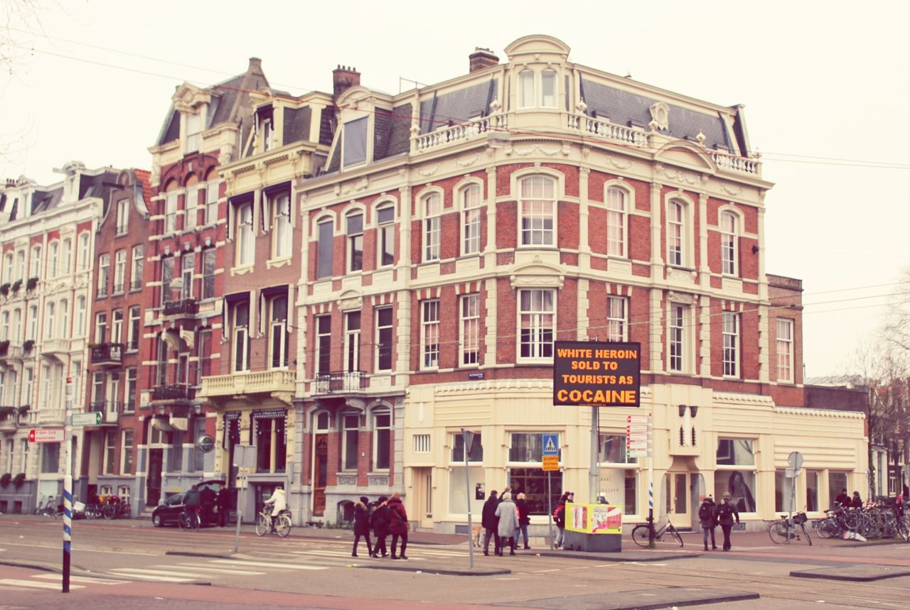 building exterior, architecture, built structure, large group of people, street, city, person, walking, men, building, city life, facade, window, day, outdoors, lifestyles, clear sky, residential structure, residential building