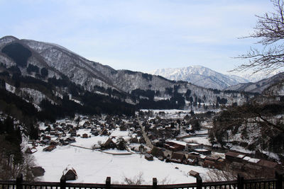 Town by mountain against sky in winter