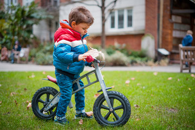 Boy playing with bicycle in grass