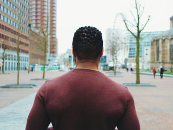 Rear view of man with umbrella in city