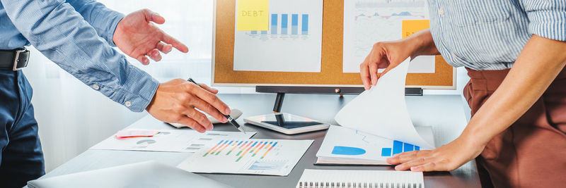 Midsection of business colleagues shaking hands at office