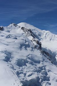 Scenic view of snowcapped mountains against blue sky