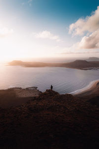 Young adult looking to the horizon in a spectacular sunset in lanzarote, canary islands