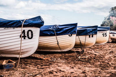 Boats moored on beach against sky