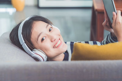 Portrait of young woman using digital tablet at home