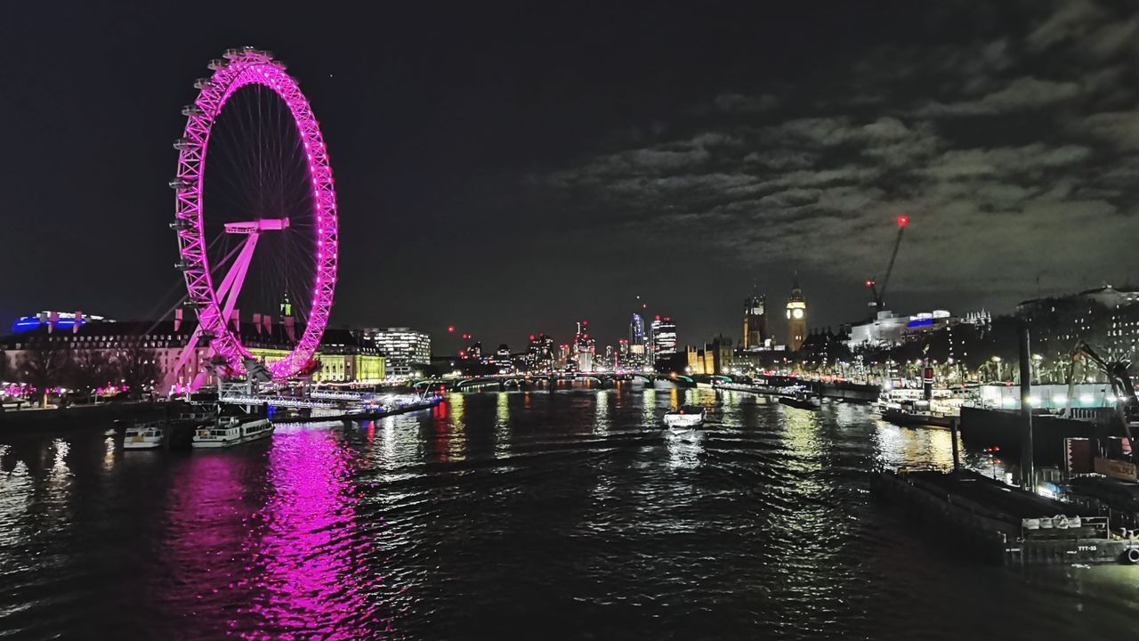 ferris wheel, amusement park ride, amusement park, night, architecture, water, illuminated, built structure, arts culture and entertainment, city, travel destinations, building exterior, sky, nature, cityscape, river, no people, reflection, transportation, waterfront, outdoors, landmark, travel, building, motion, tourism, skyline, city life, nightlife, multi colored, bridge