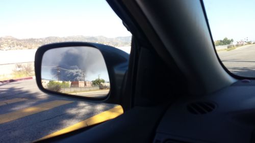 Reflection of smoke on car side-view mirror