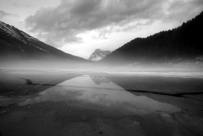 Scenic view of lake by mountains against sky