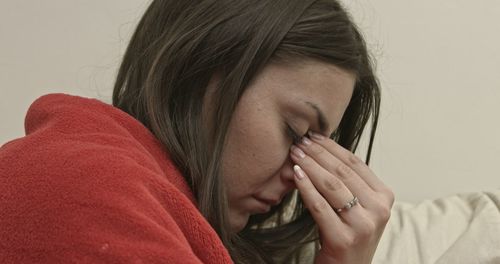 Close-up of depressed woman against wall