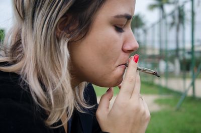 Close-up of woman smoking marijuana joint