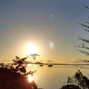 Sun shining through clouds over sea