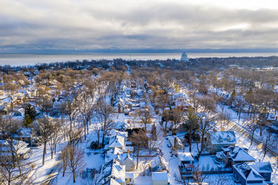 Scenic view of snow covered townscape against sky