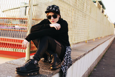 Portrait of stylish young woman standing against building. teenager. city landscape.construction net