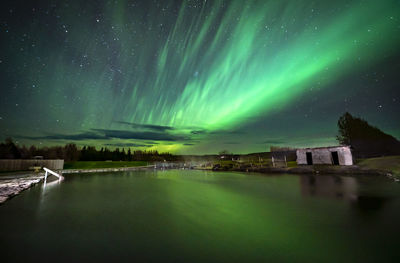 Secret lagoon in flúðir village in iceland with northern lights reflecting in the pool water