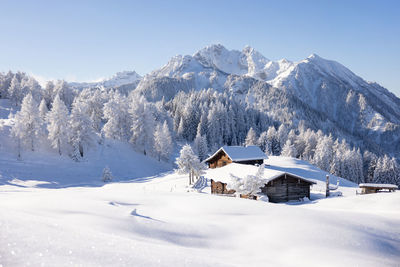 Traditional wooden house in the alps covered with snow.