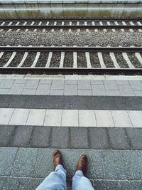 Low section of man standing on railroad track