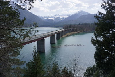 Scenic view of lake and mountains against sky with bridge