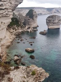 High angle view of rock formation in sea against sky