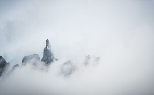 Low angle view of snow covered mountains against sky