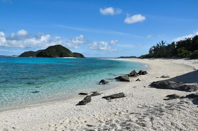 Scenic view of beach against blue sky