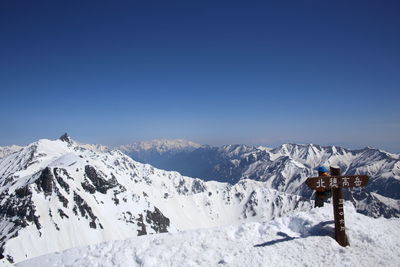 Scenic view of snowcapped mountains against clear blue sky