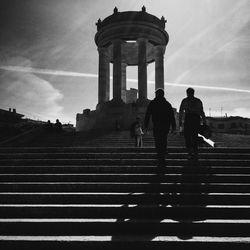 Silhouette of people in front of building