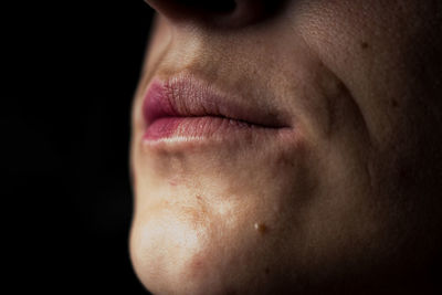 Close-up of man wearing lipstick in darkroom