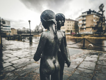 Close-up of statue against city in background