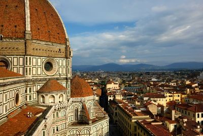 Florence cathedral in city against cloudy sky