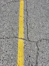 High angle view of yellow arrow symbol on road