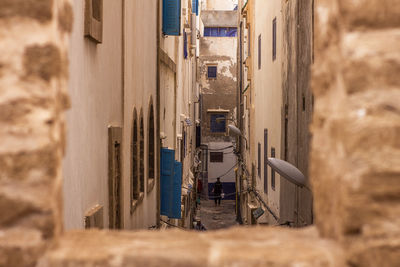 Alley amidst buildings in field