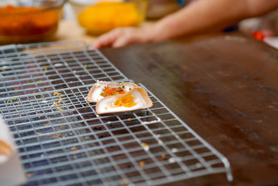 Close-up of person preparing food on barbecue grill