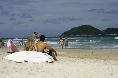 People at beach against sky