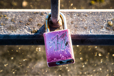 Close-up of padlocks hanging on metal railing