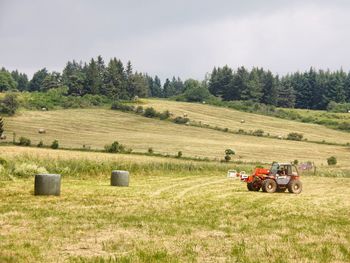 Tractor on agricultural field against sky