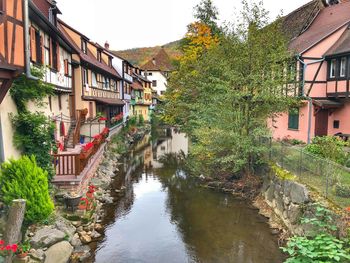 Canal amidst houses against buildings in city