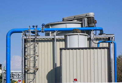 Low angle view of factory against clear blue sky