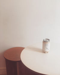 Close-up of empty coffee on table against wall