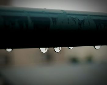 Close-up of water drops on roof against sky