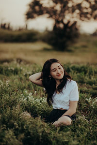 Portrait of beautiful young woman on field