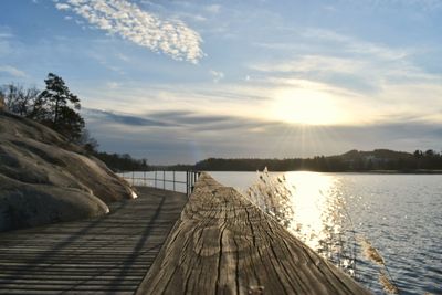 Pier over lake against sky during sunset