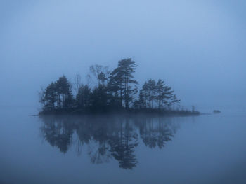 Reflection of trees in lake against sky